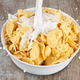 Milk poured over bowl of healthy flakes cereal